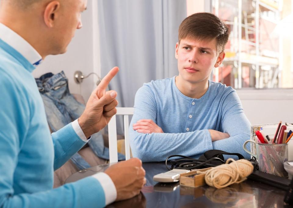 اب يجلس مع ابنه يتحادث معه بحزم مشيرا باصبعه للحفاظ على حدود الاحترام بينهما 