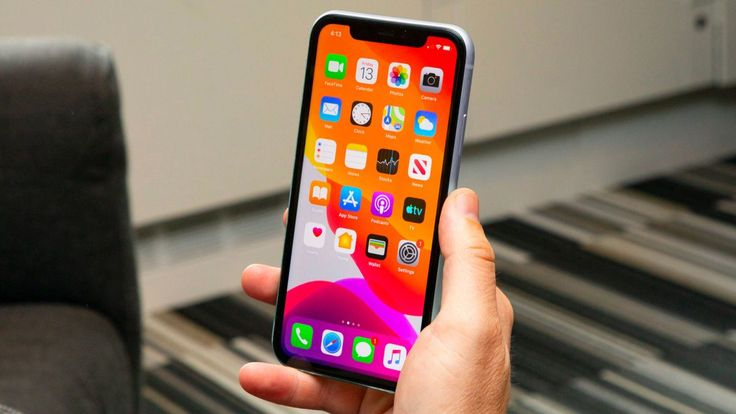 يد تمسك جهاز ايفون حديث تظهر على شاشته التطبيقات المتوفرة 