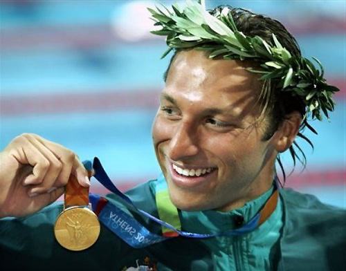 السباح العالمي إيان ثورب و هو يضع اكليل النصر و يحمل بيده ميدالية ذهبية معلقة برقبته 
