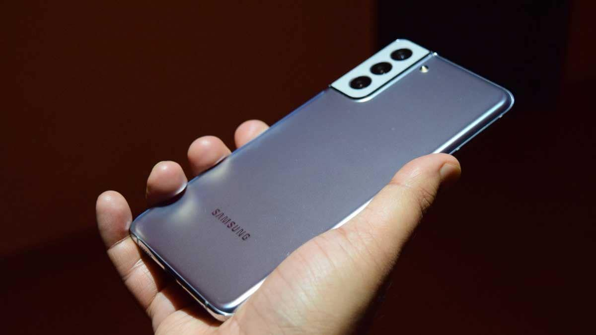 يد تمسك جهاز سامسونج وتظهر خلفية الموبايل وكاميراته المختلفة