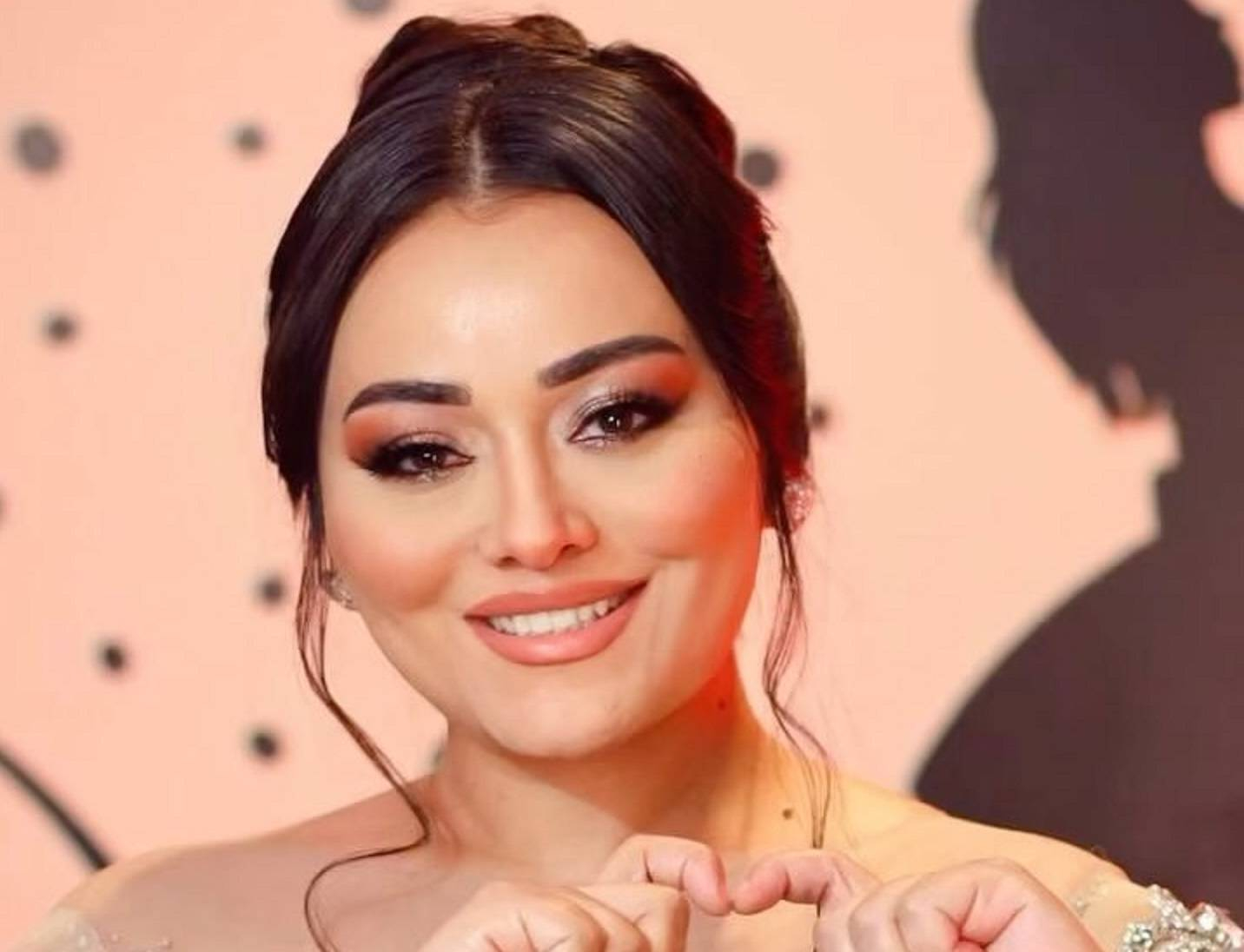 الممثلة رنده البحيري وهي ترفع شعرها وهي مبتسمة 