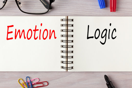 على طاولة يظهر دفتر مفتوح مكتوب على كل صفحة كلمتة  Emotion والثانية Logic