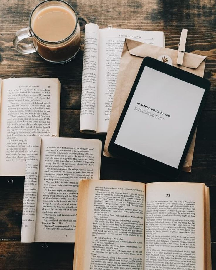 على طاولة تظهر مجموعة من الكتب الورقية و بجانبها كتاب الكتروني 