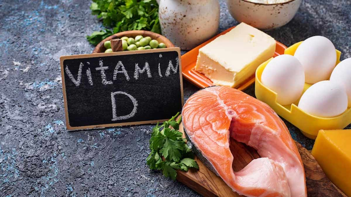 فيتامين دال لوح خشبي مكتوب عليه VITAMIN D وبجانبه اغذية غنية بفيتامين دال مثل البيض و السمك و البازيلاء والزبده