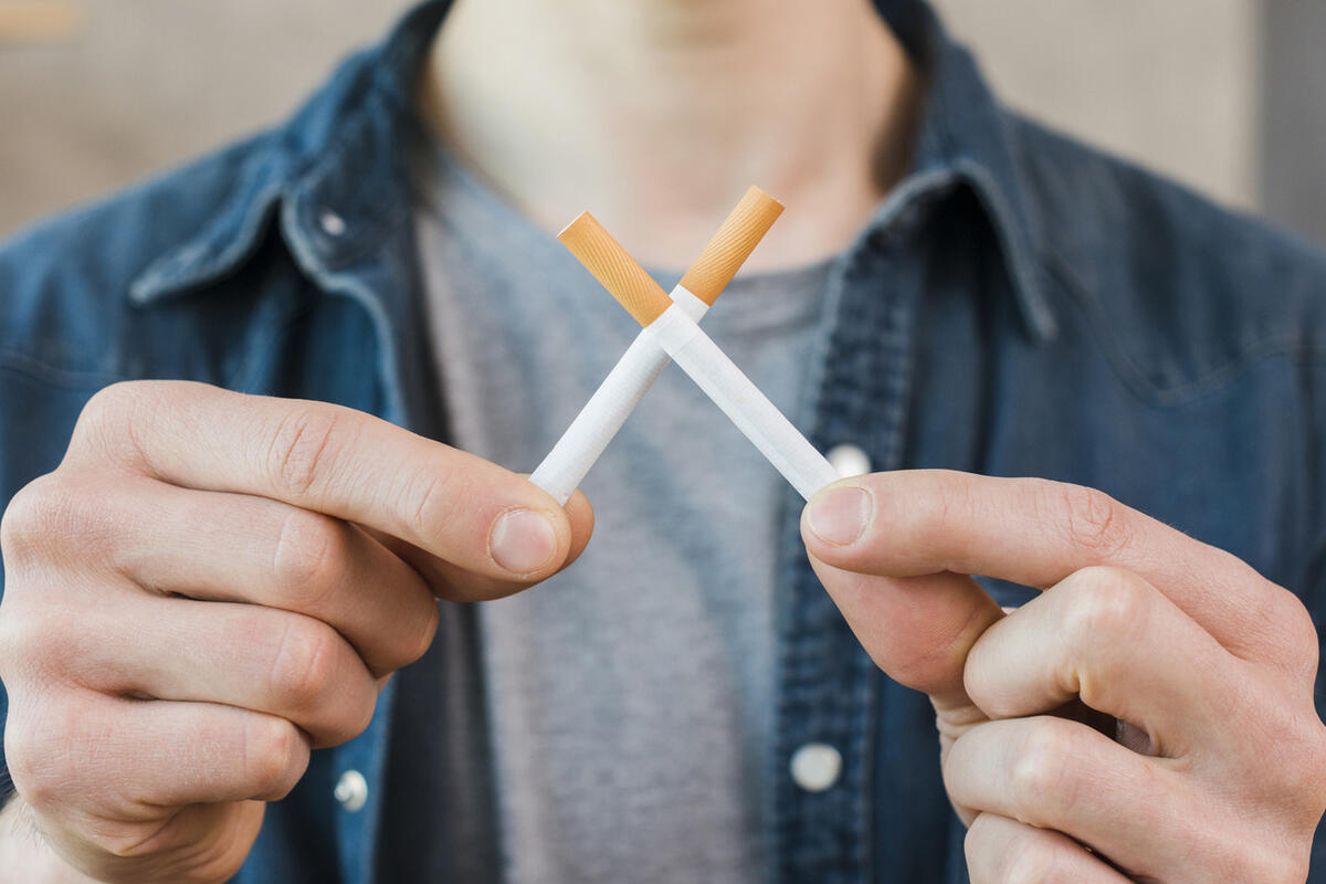 رجل يمسك سيجارتين على شكل x 