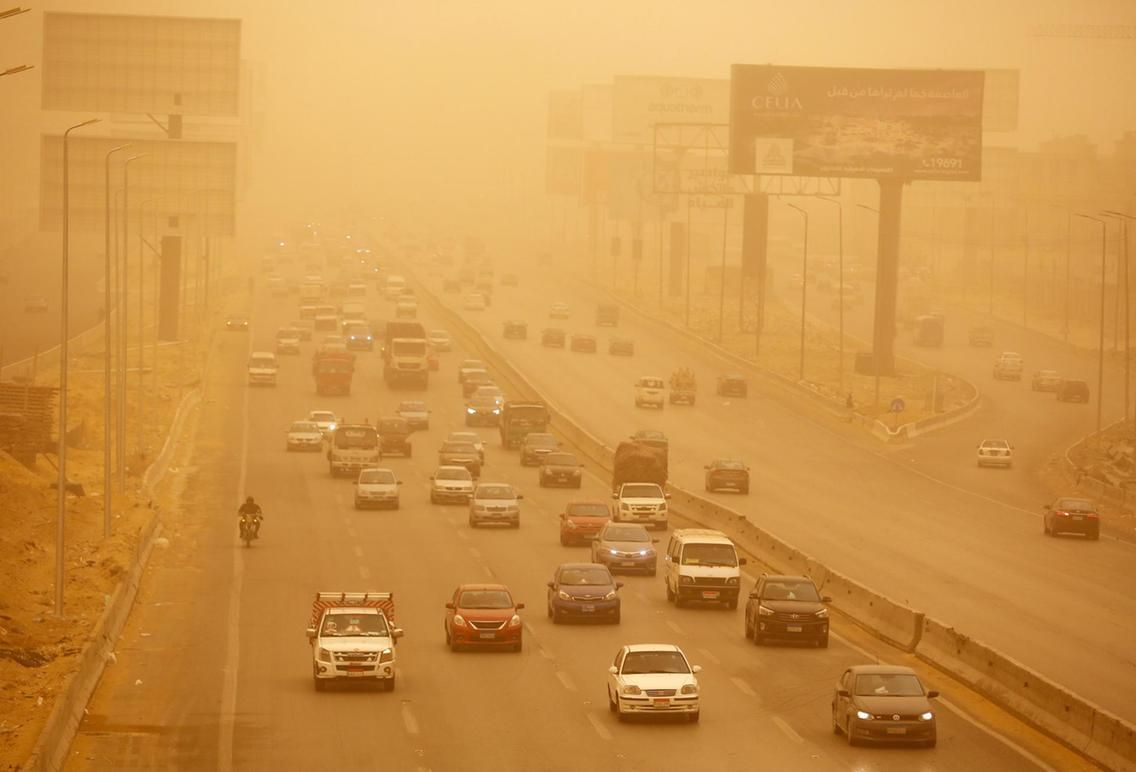 ضبابية الرؤية في المدينة بسبب العاصفة الرملية و تظهر السيارات وهي تشعل الاضواء ليتمكنوا من الرؤية