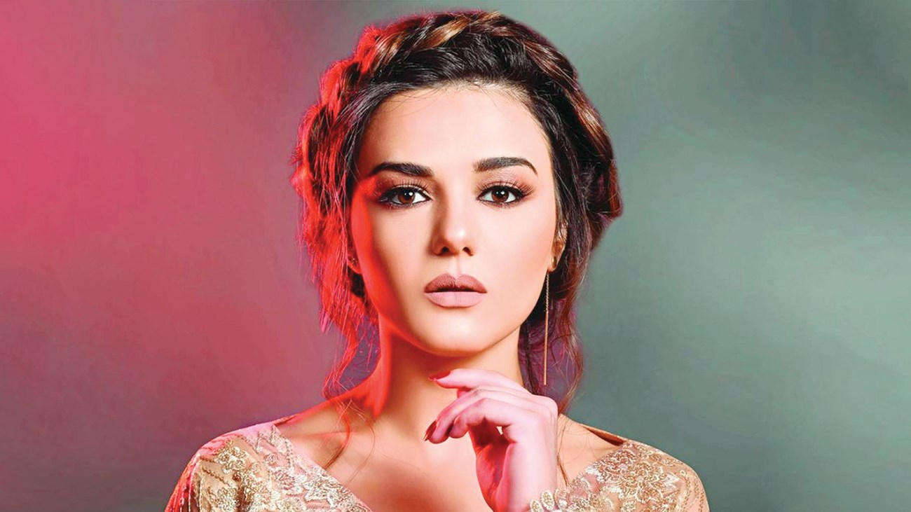 الممثلة دانا مارديني وهي تضع يدها تحت ذقنها و ترفع شعرها بطريقة لطيفة 