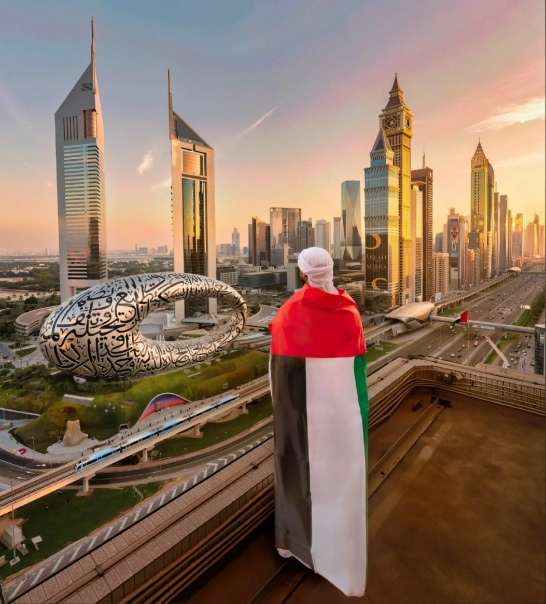 شاب اماراتي يضع على كتفيه علم الامارات و يقف على شرفة مطلة على ابنية رائعة في الامارات 