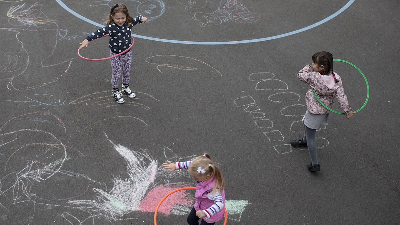 في لندن ، يلعب الأطفال بشكل منفصل في ملعب المدرسة