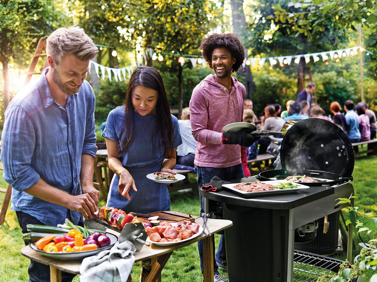 عائلة تقضي اوقات لطيفة في عطلة نهاية الاسبوع ويتشاركون تحضير الطعام في الهواء الطلق