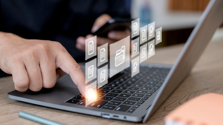 شخص يستخدم اللابتوب و تظهر بشكل افتراضي ايقونات الملفات 