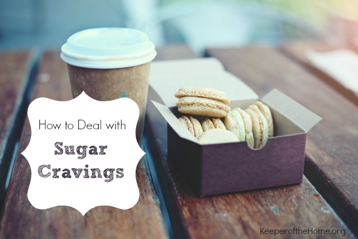 على طاولة خشبية تظهر علبة من الحلويات و بجانبها كأس و عبارة How to Deal with Sugar Cravings 