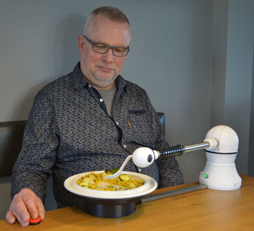 روبوت لتقديم الرعاية اليومية حيث يظهر في الصورة وهو يطعم عجوز