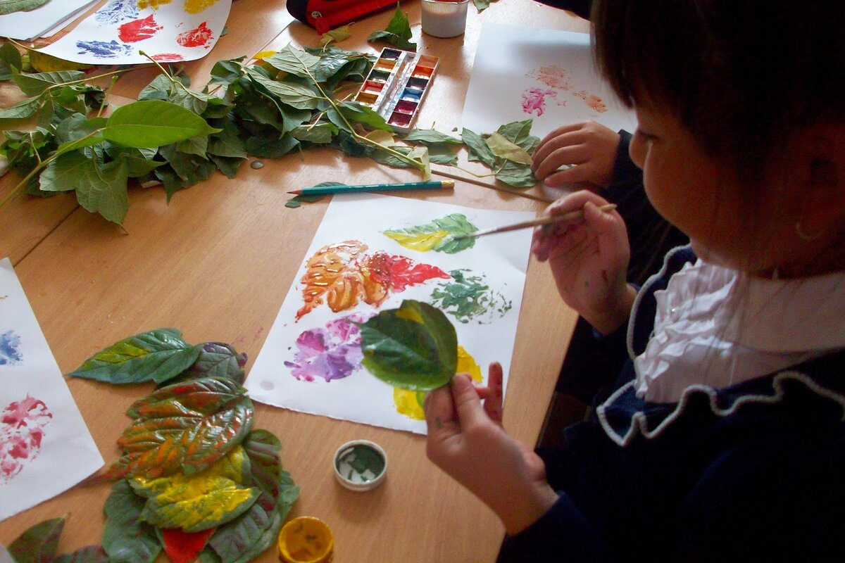 طفل يبدع في الرسم باستخدام اوراق الاشجار 