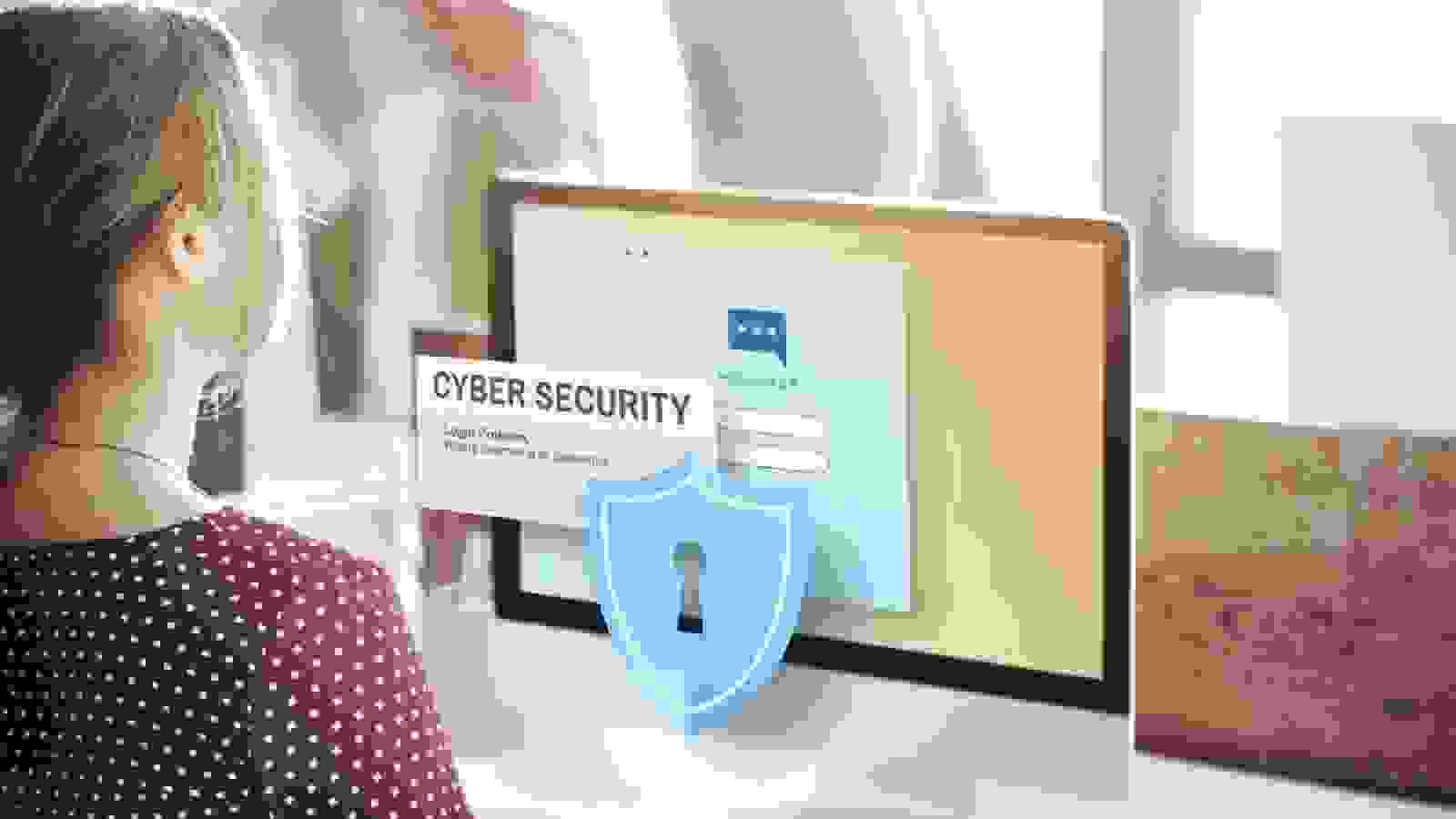 فتاة تجلس الى طاولة أمامها شاشة تظهر عليها قفل حماية 