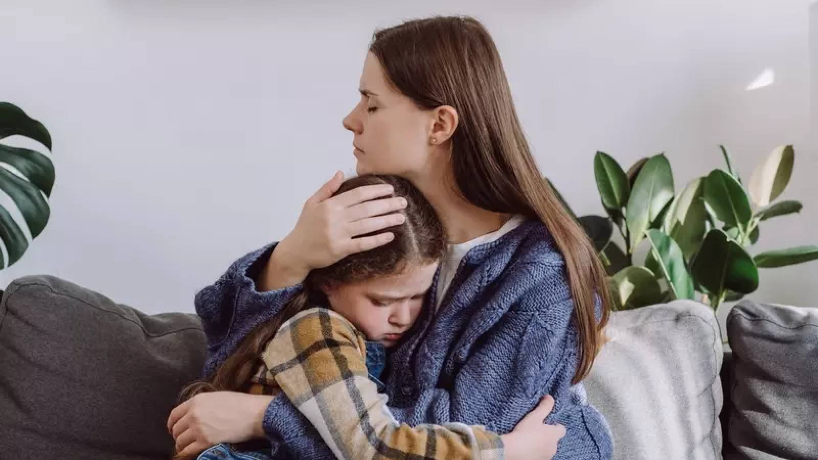 ام تحتضن طفلتها وتتعاطف معها في موقف يؤلمها 