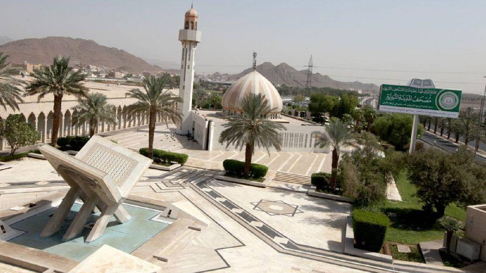 بناء مجمع الملك فهد لطباعة المصحف الشريف و بجانب النباء مجسم  للمصحف 