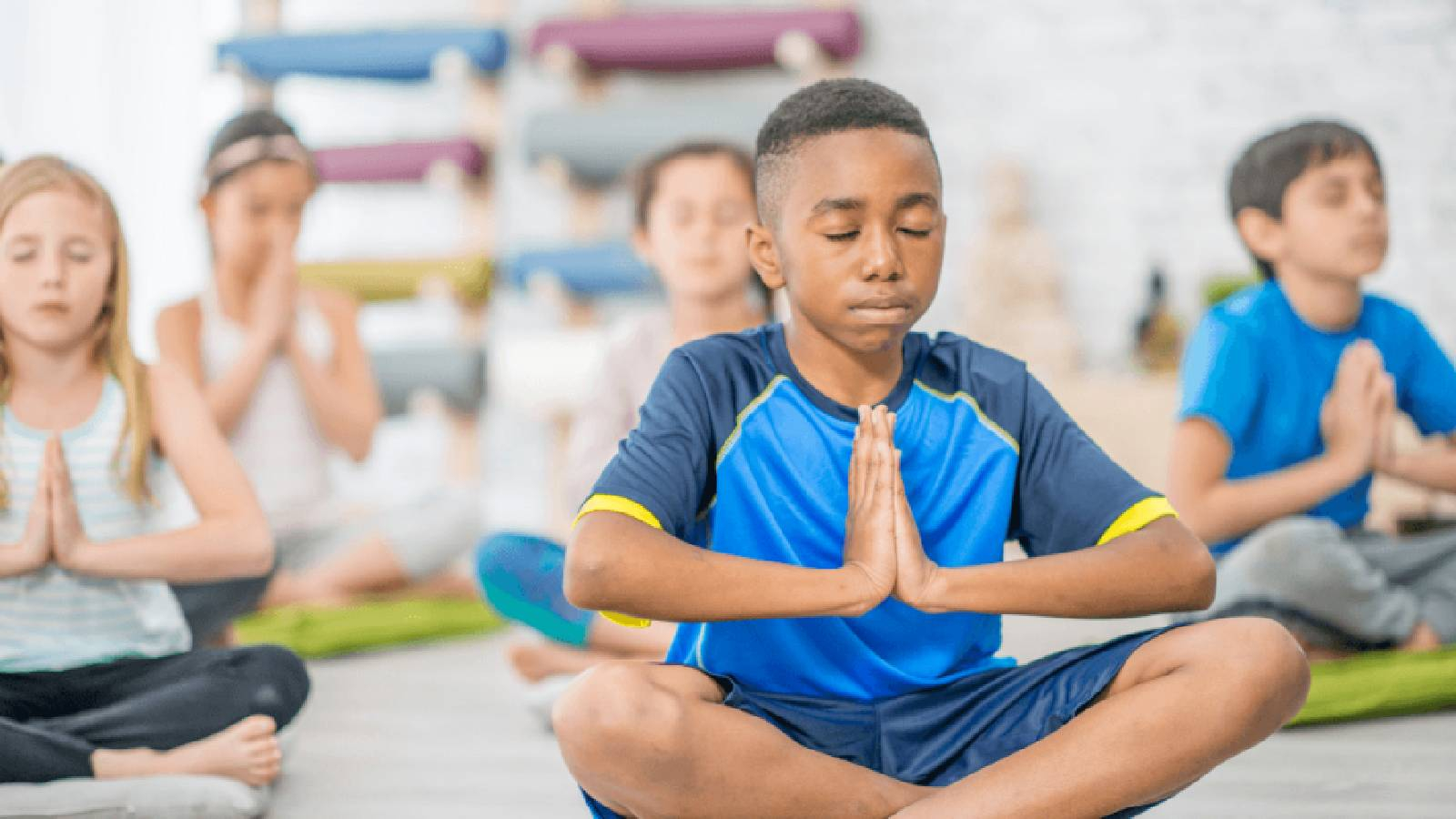 مجموعة من الاطفال يمارسون رياضة التأمل لتعزيز الذكاء العاطفي لديهم 