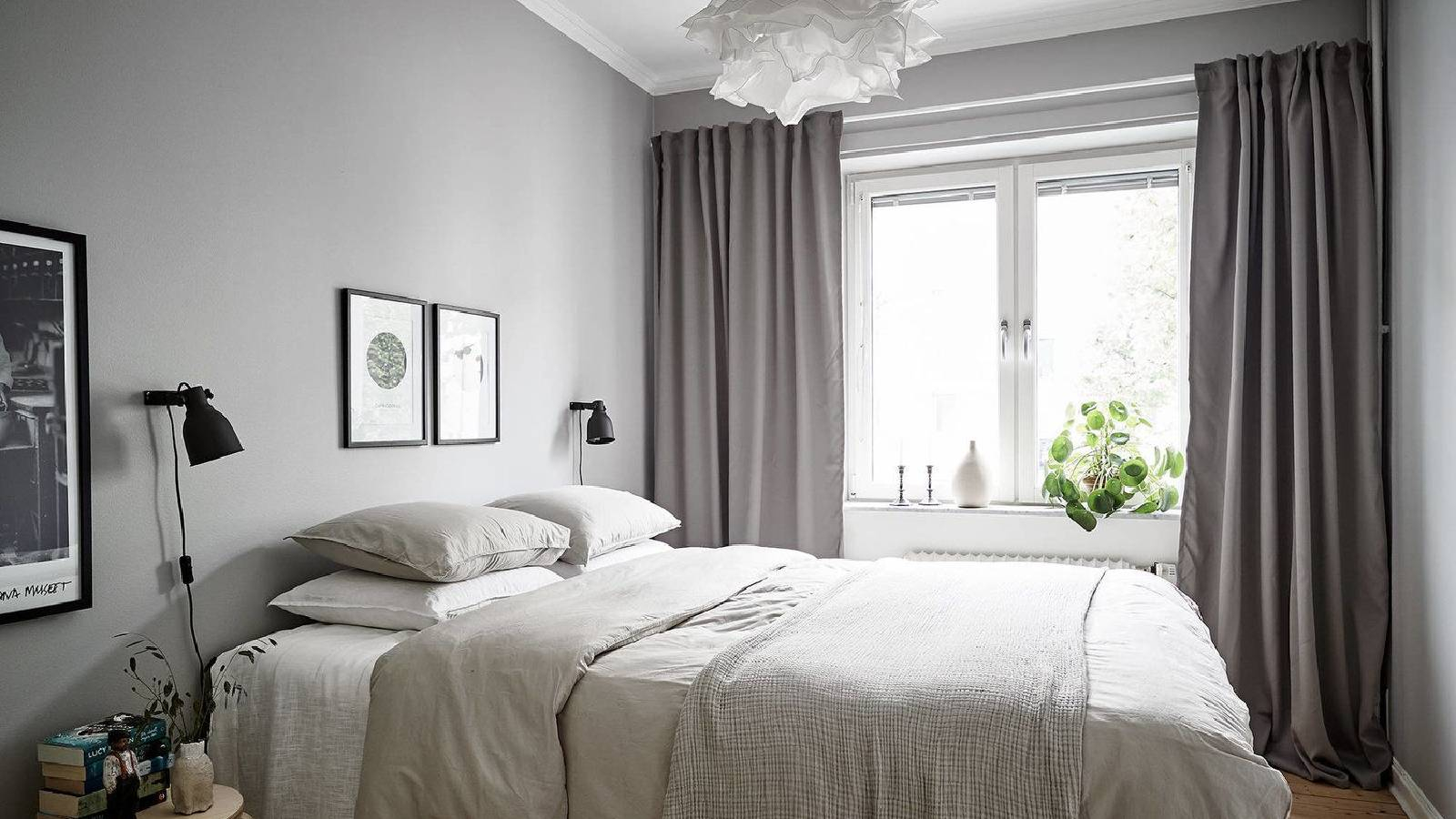 غرفة نوم يطغى عليها اللون الابيض والرمادي والفتح مع ستائر رمادية 