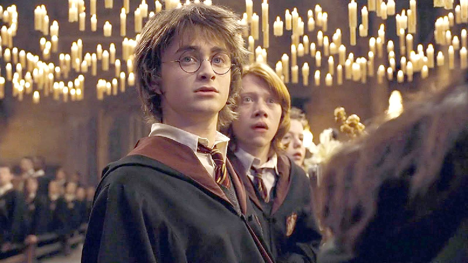 الصورة من داخل مدرسة لتعليم السحر و يقف في المنتصف بطل الفيلم وصديقة وهو ينظر نظرة دهشة و عدد كبير من الشموع معلقة في الهواء وهي مضاءة 
