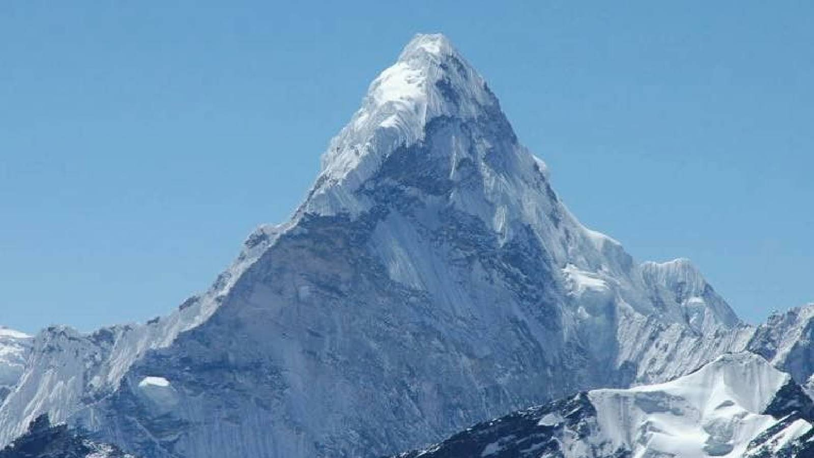 قمة جبلية عالية وسفوح شاهقة وحادة تغظي قمتها الثلوج