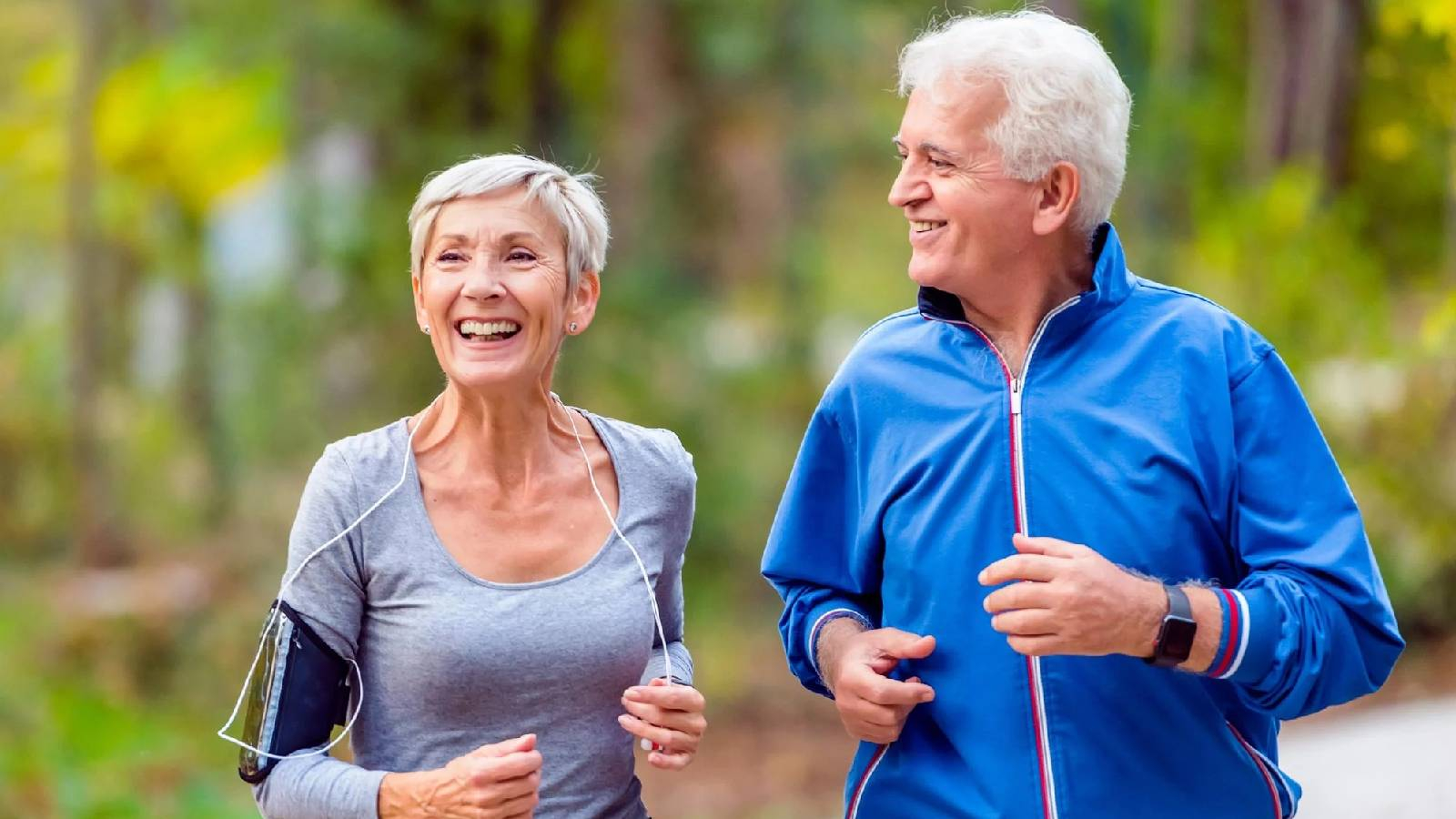 رجل وامرأة مرتديان الزي الرياضي و يركضان في الطبيعة 