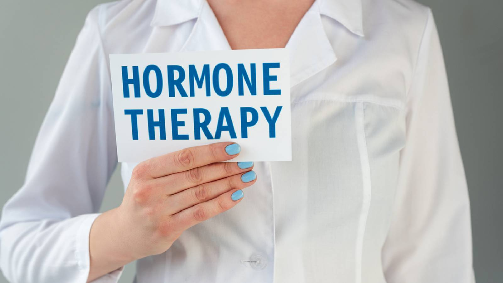 طبيبة تحمل لافتة صغيرة مكتوب عليها HORMONE THERAPY