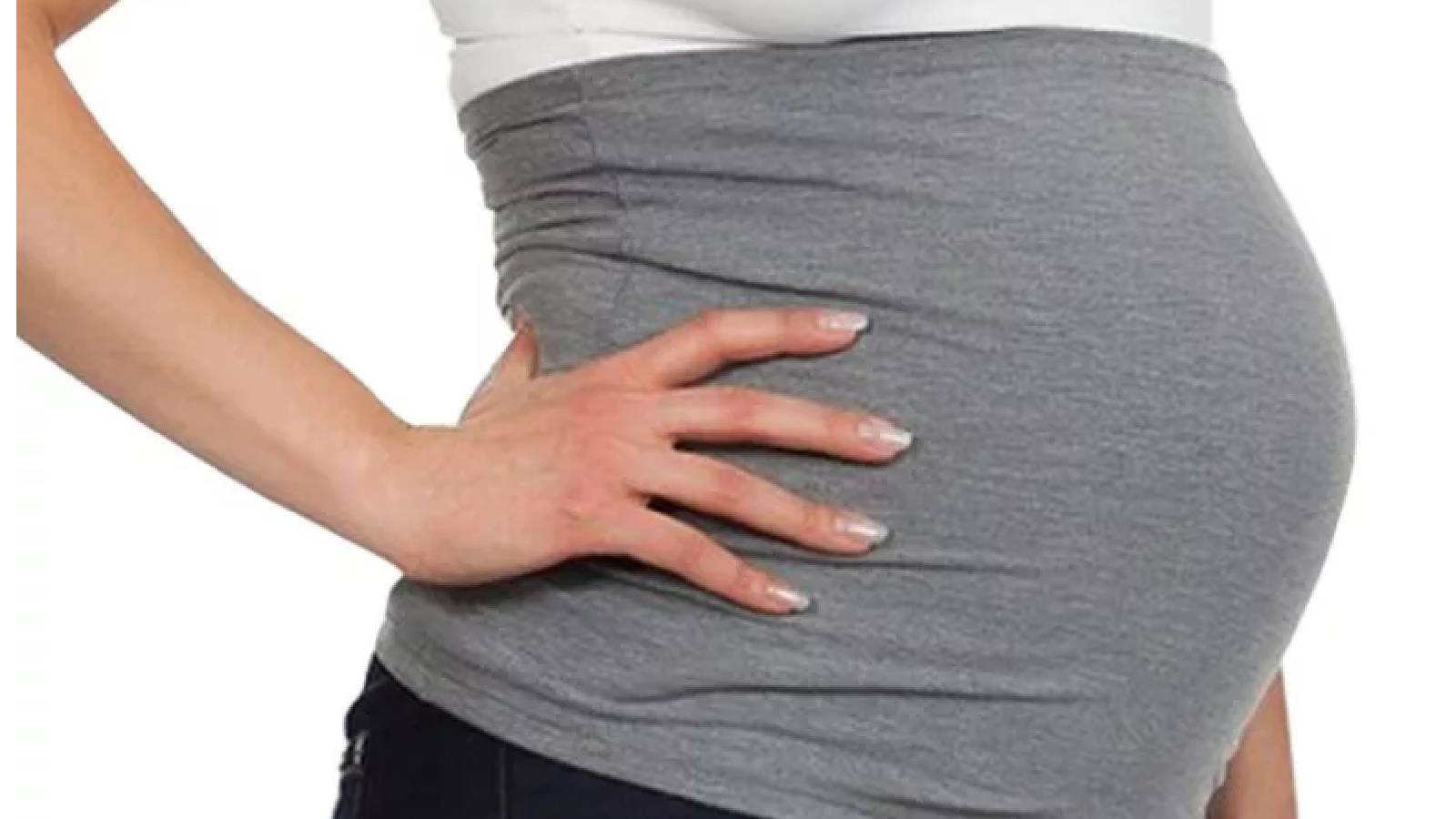 امرأة حامل تضع حزام للبطن باللون الرمادي واضعة يدها اليمنى على خصرها 