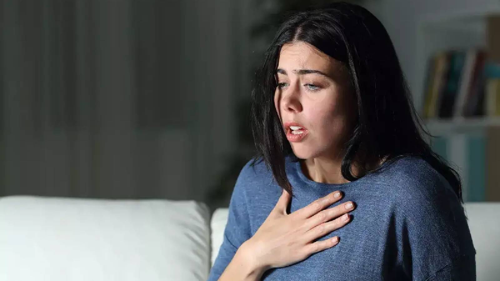 سيدة تضع يدها على صدرها وهي تعاني من ضيق التنفس بسبب متلازمة الابنية المريضة 