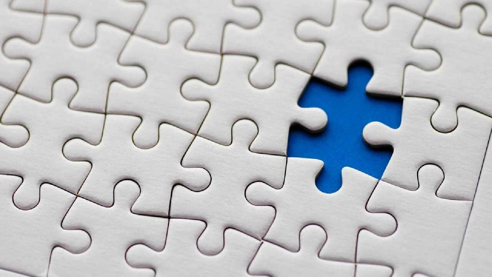 مجموعة من قطع الالغاز البيضاء مرصوفة بشكل متناسق و يوجد قطعة ناقصة تظهر باللون الازرق 