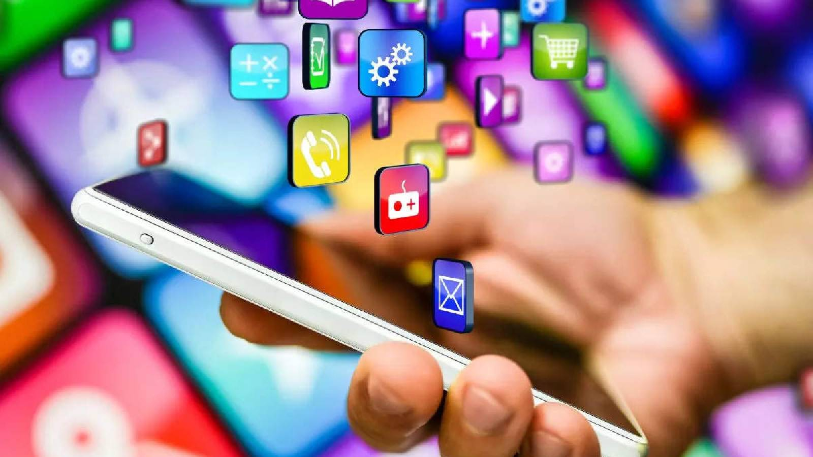 يد ممسكة بهاتف ذكي و تظهر فوقه ايقونات لتطبيقات كثيرة 