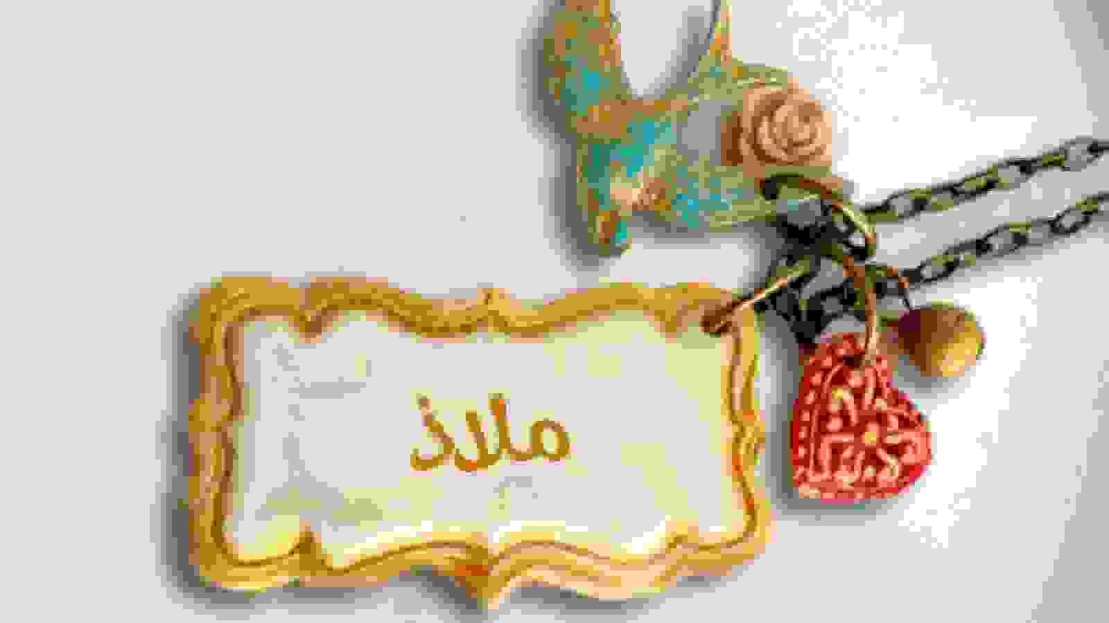 على خلفية بيضاء تظهر قلاده فيها قلب احمر و عصفور وقطعة مستطيله وفي الوسط مادة بيضاء مكتوب عليها اسم ملاذ
