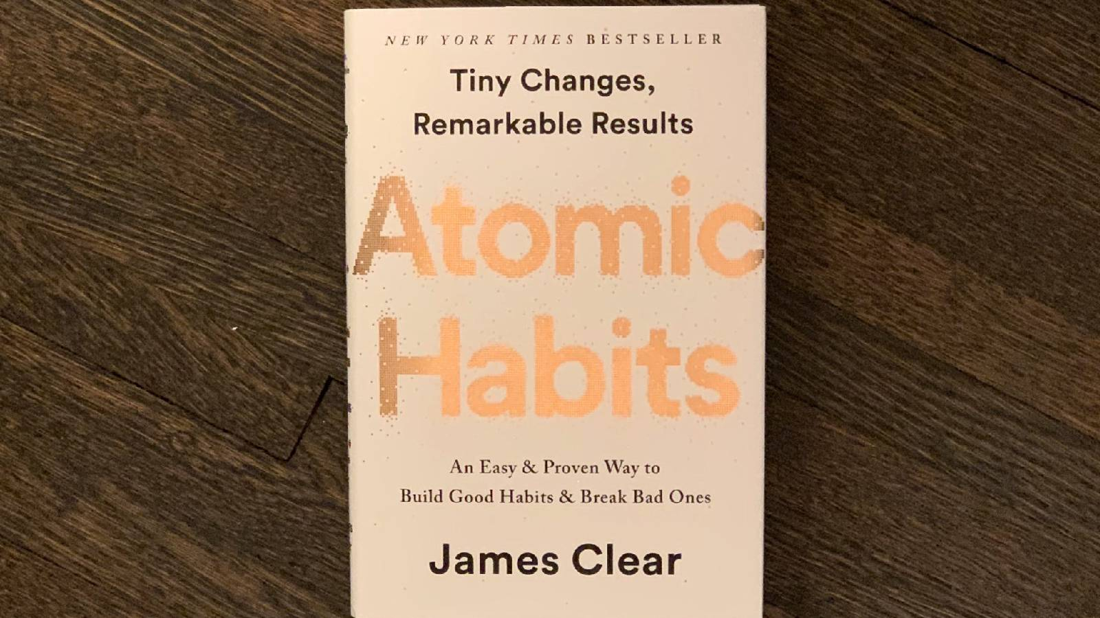 كتاب العادات الذرية  غلى طاولة خشبية يظهر كتاب العادات الذرية