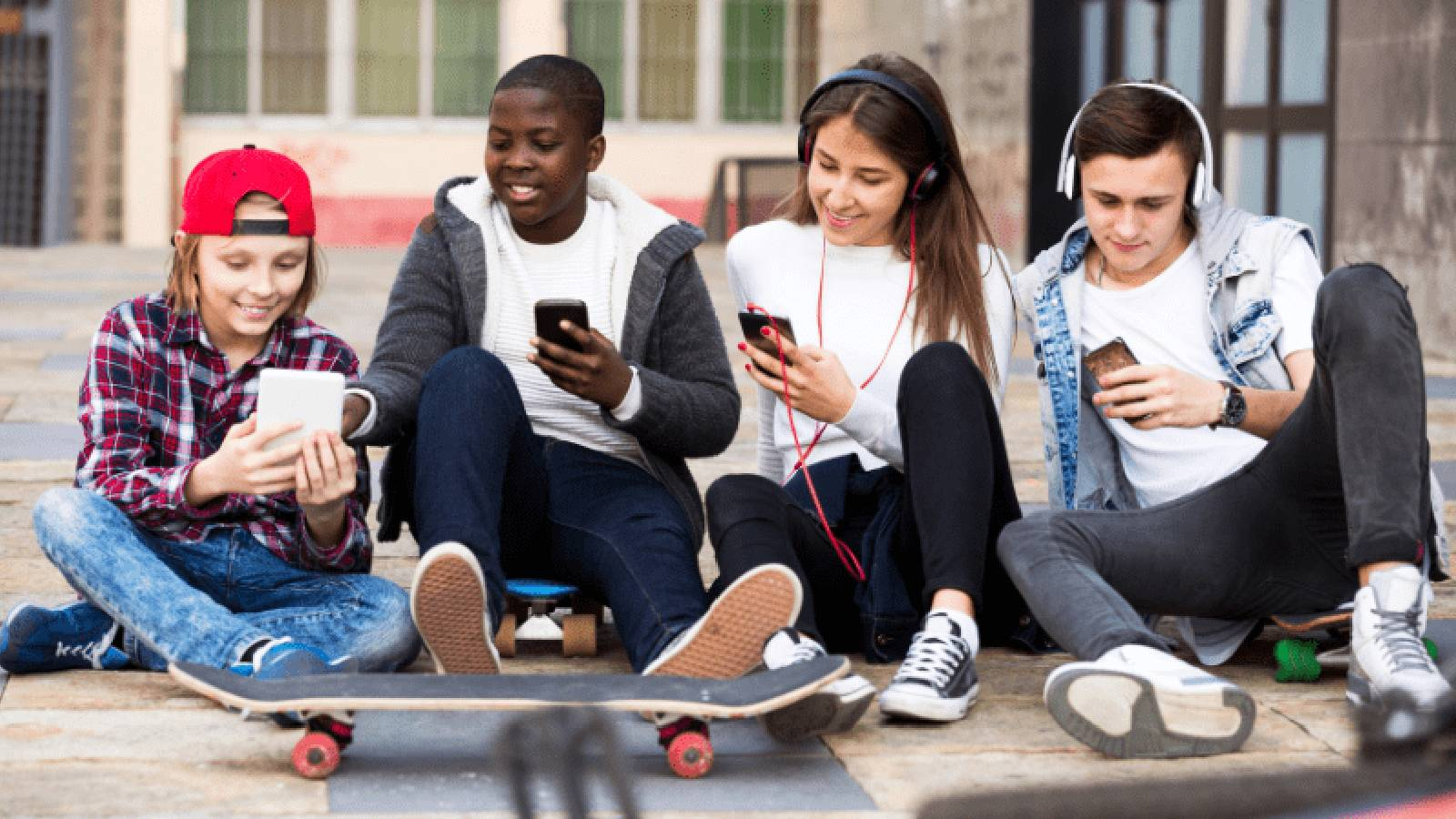 مجموعة من الشبان يحملون اجهزة الهواتف الذكية و يتواصلون عبرها 