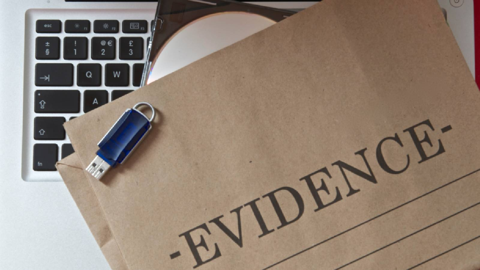 على لوحة مفاتيح لجهاز لابتوب يظهر مغلف و فلاشة و سي دي و تظهر عبارة EVIDENCE